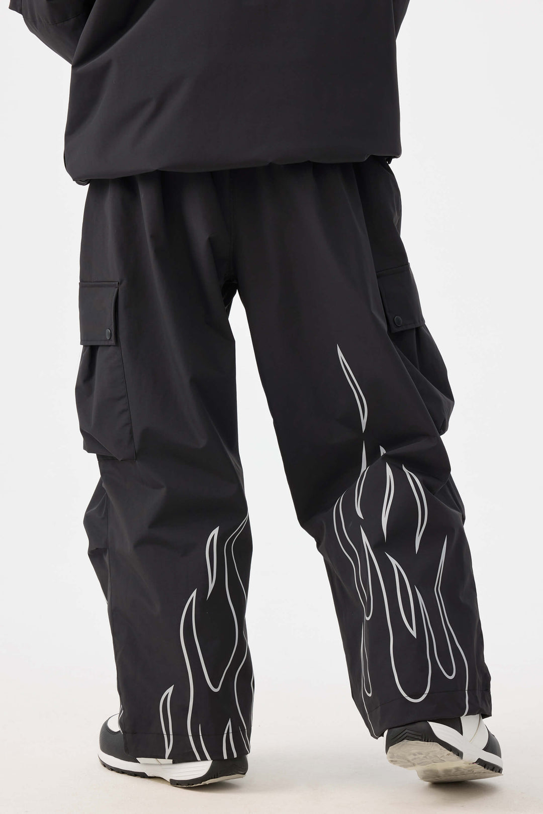 Calça de neve feminina preta com estampa refletiva de chamas, modelo folgado e utilitário.