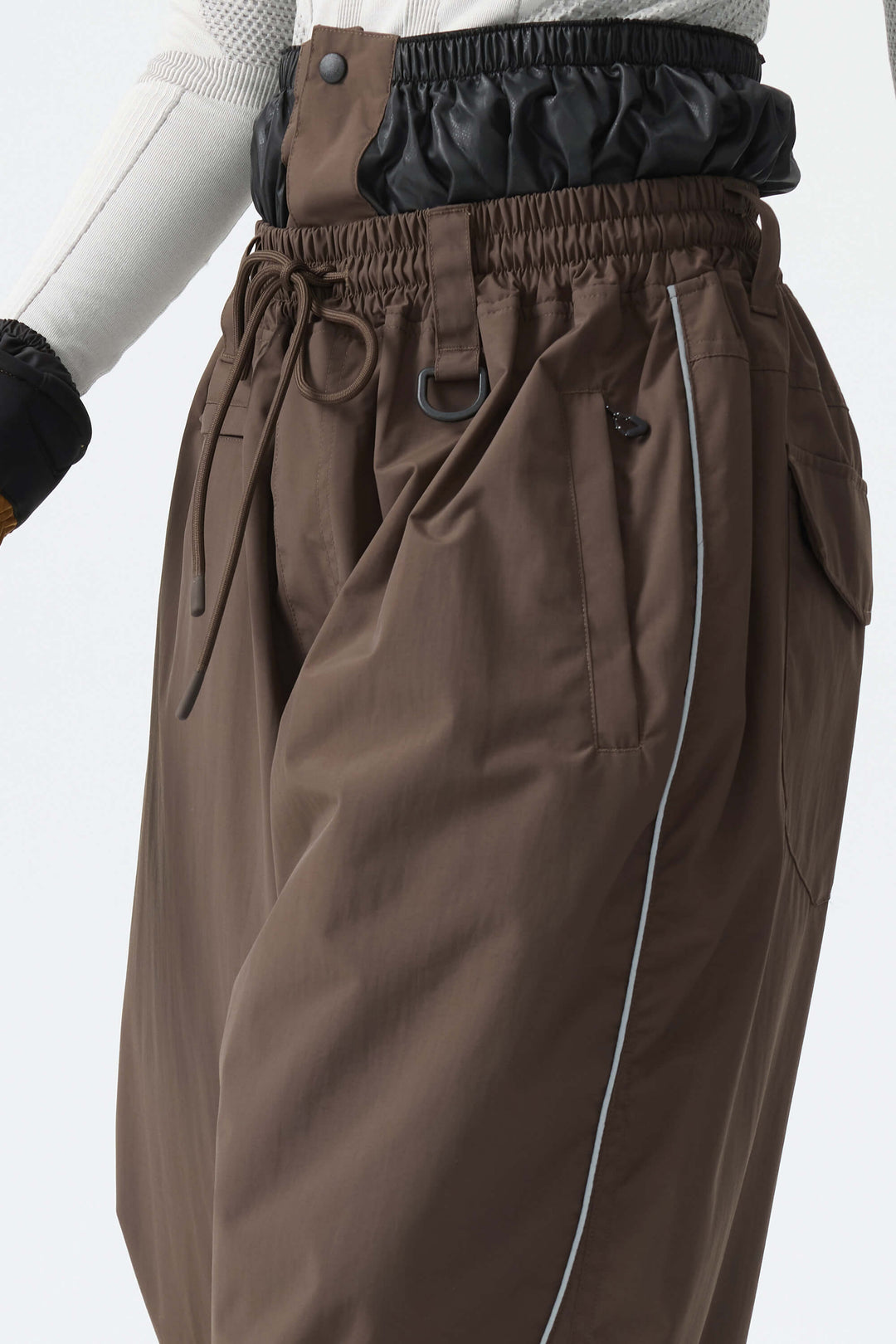 Calça de neve feminina marrom, folgada, com detalhes refletivos e cordão.