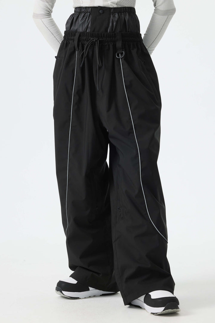 Calça de neve feminina preta, larga e com detalhes refletivos.