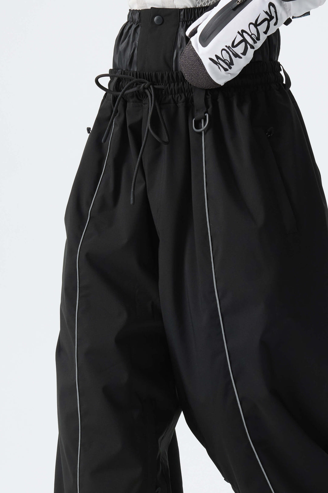 Calça de neve feminina preta, larga e com detalhes refletivos.