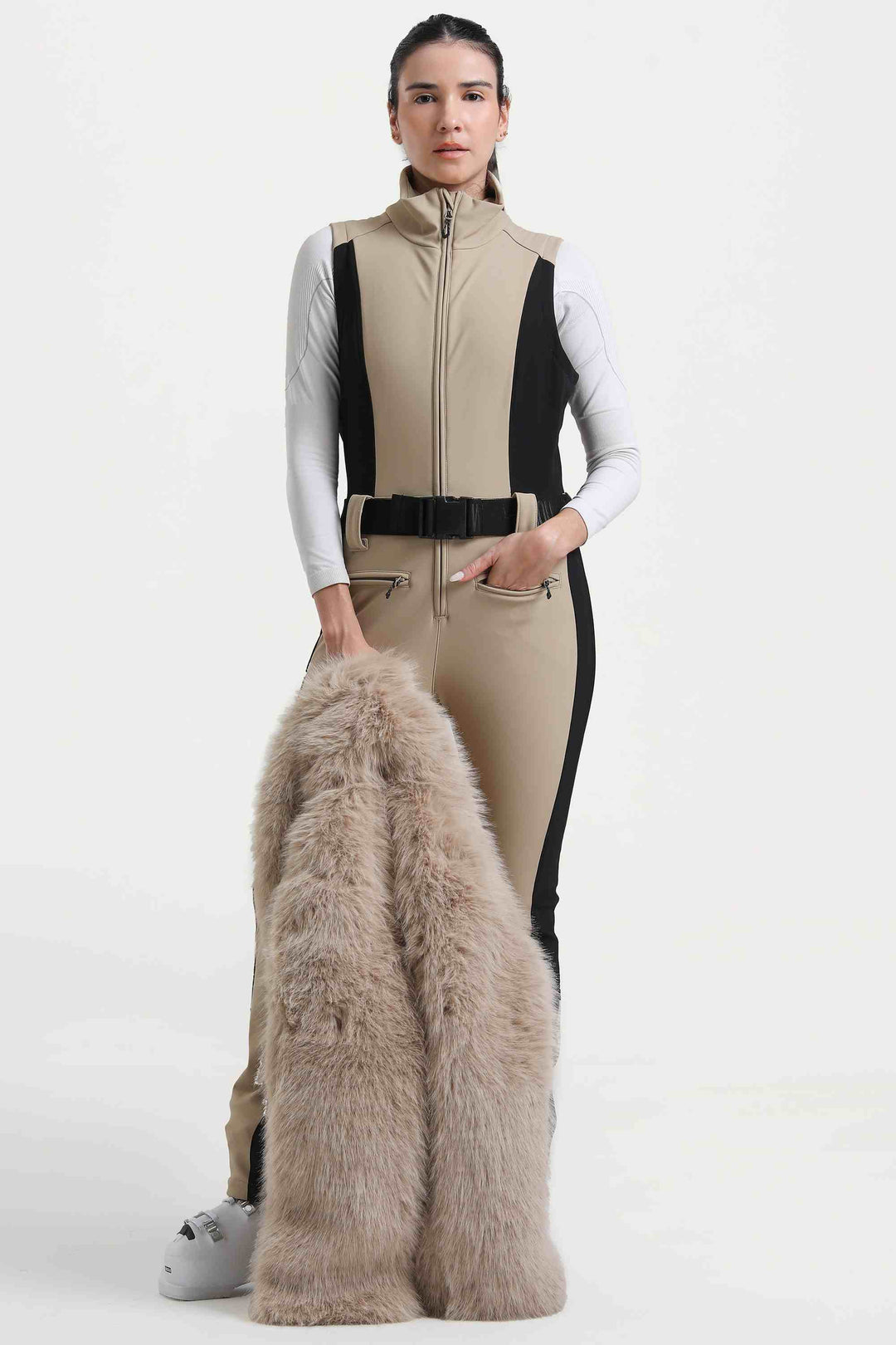 Weißer, stylischer, schmal geschnittener einteiliger Skianzug für Damen mit abnehmbarer Jacke aus Kunstfuchspelz und ausgestellten Beinen 